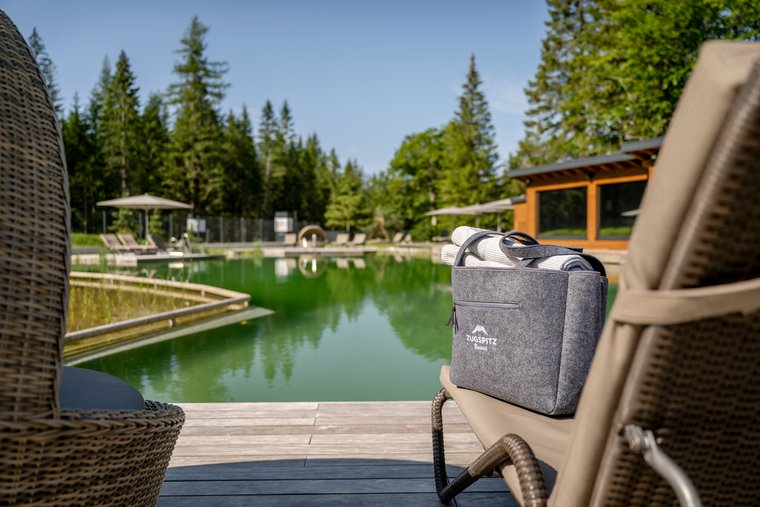 Badetasche auf Liegestuhl am Schwimmteich