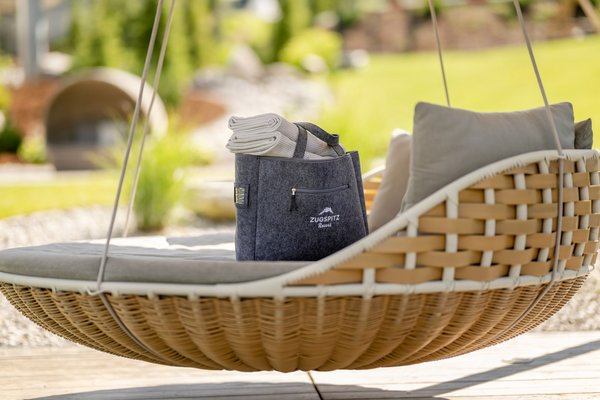 Badetasche auf Schwebeschaukel im Garten