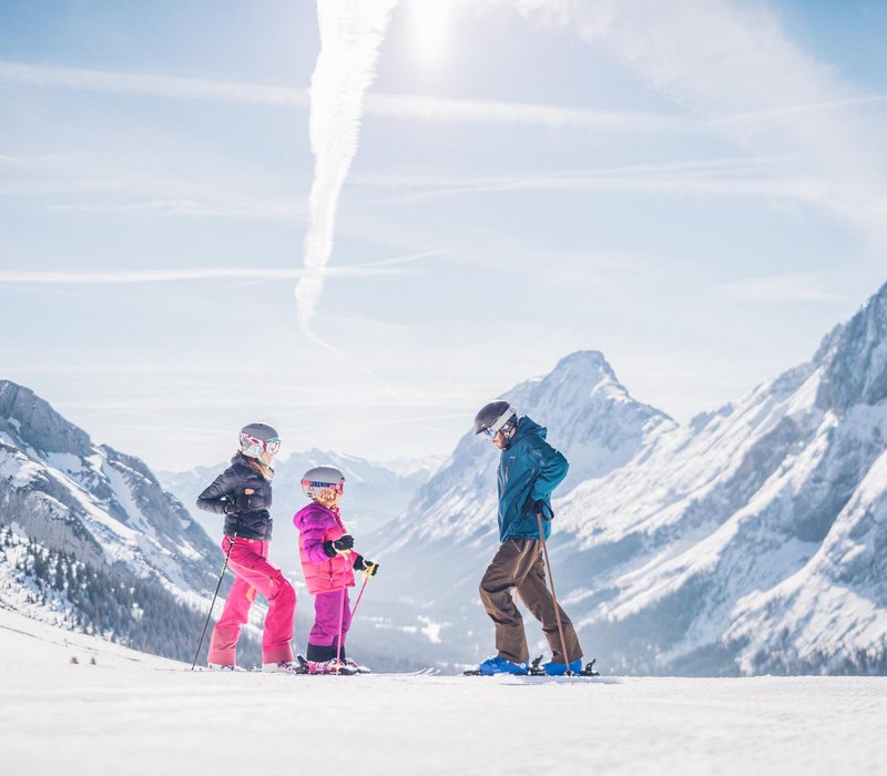 Familie beim Skifahren auf der Piste